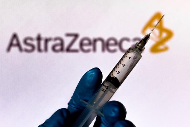 מזרק על רקע של שלט חברת אסטרה זניקה , ממחיש את מרוץ החיסון לקורונה